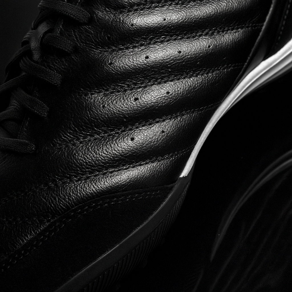 Close-up of a black leather shoe with visible stitching