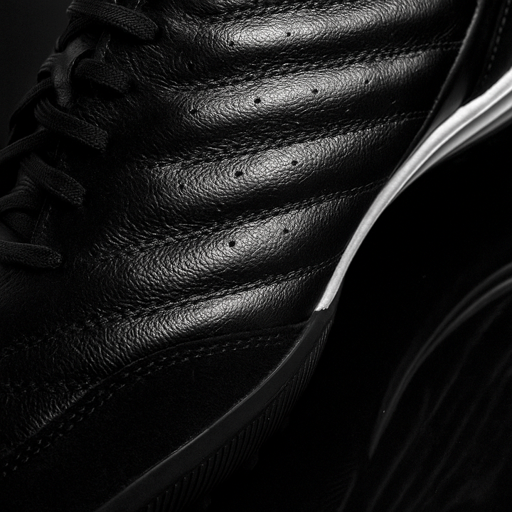 Close-up of a black leather shoe with visible stitching