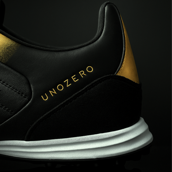 Black and gold sneaker with 'UNOZERO' branding on a black background